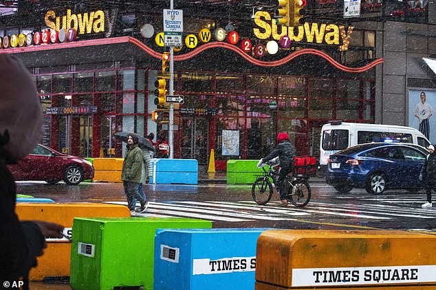 On Sunday people walk through Time Squares in a wintery mix