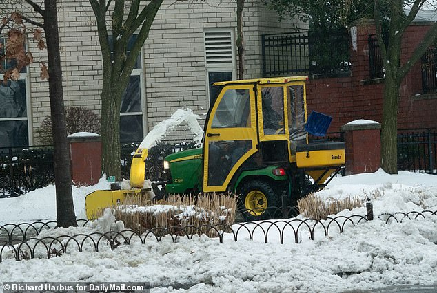 Workers use a snowplow to clear snow in White Plains, New York, on Sunday