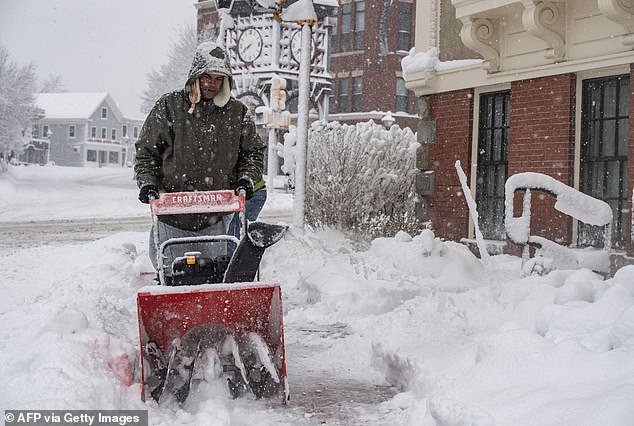 A person uses a snow blower to clear snow in front of a home in Methuen, Massachusetts, on Sunday