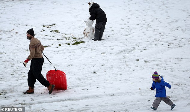 People play in the first snow of the winter season in Nyack, New York on Sunday