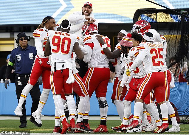 Travis Kelce, who did not play on Sunday, congratulates Chris Jones after a sack