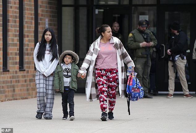 A woman walks out of the McCreary Community Building, the current reunion site where parents can find their children after the Perry School shooting