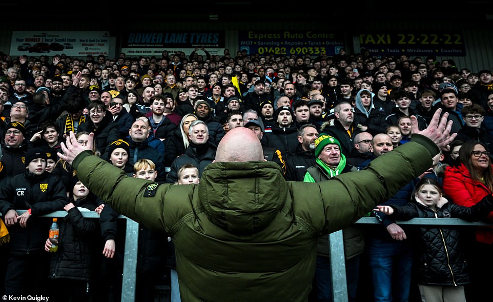 A supporter, happy in a thick green jacket, tried to urge his colleagues into the stands as Maidstone closed in on their triumph