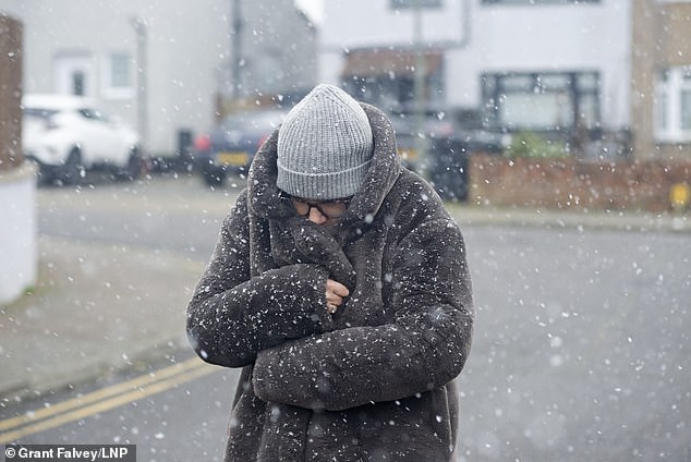 As a woman is caught in a snowfall on the street in Orpington, south-east London, this morning, experts claim a cold dip or run when the air is crisp - even if only for a short time - will do wonders for your health (Photo: Grant Falvey/LNP)