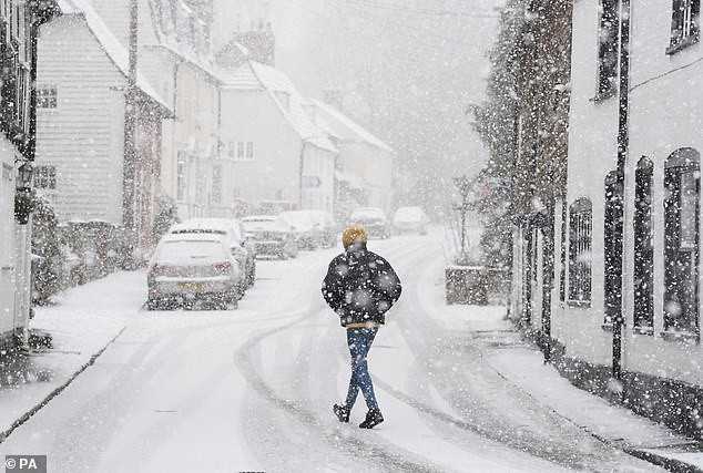 A person walking through a snowstorm in Lenham, Kent, this afternoon