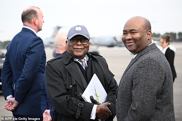 Representative Jim Clyburn (D-SC) (L) and Democratic National Committee (DNC) Chairman Jaime Harrison (R) wait to greet US President Joe Biden at Charleston Air Force Base