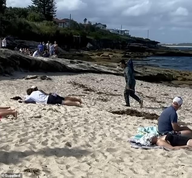 Amazed locals watched as the man slung the fish over his shoulder and carried it onto the beach, reportedly hurling 'abuse' at onlookers