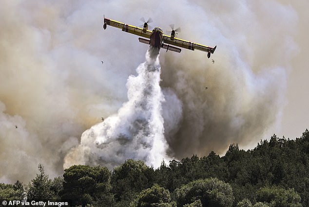 A Canadair firefighting plane sprays water during a fire in Dervenochoria, northwest of Athens, on July 19, 2023