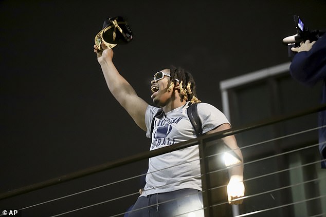 Wolverine defensive lineman Kris Jenkins salutes the fans who braved the conditions