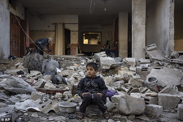 A Palestinian boy sits on the rubble of a destroyed building after an Israeli attack in Rafah