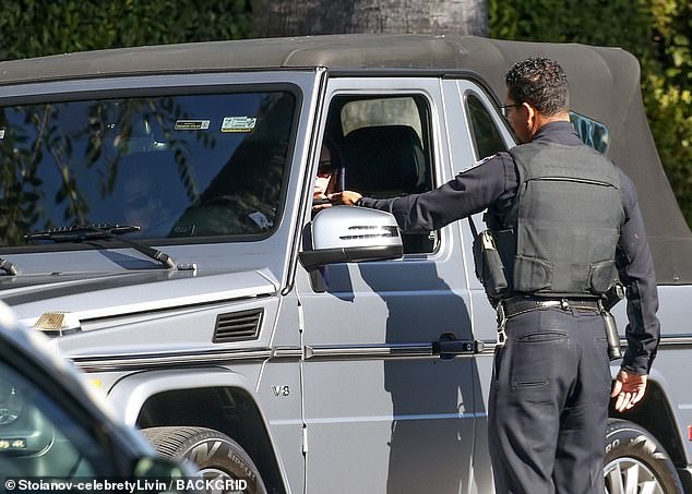 The officer is seen handing an item to the TV personality after she was stopped during an outing in Beverly Hills