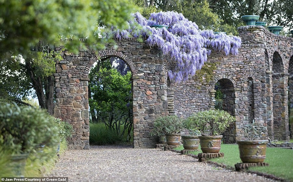 Outdoor architectural features are flanked by lush flora