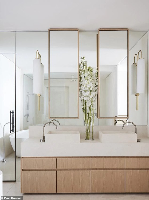 The sunny master bathroom features his and hers sinks and a minimalist design