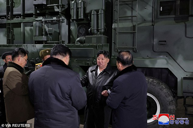 Kim (seen second right), who urged factory workers to modernize and 