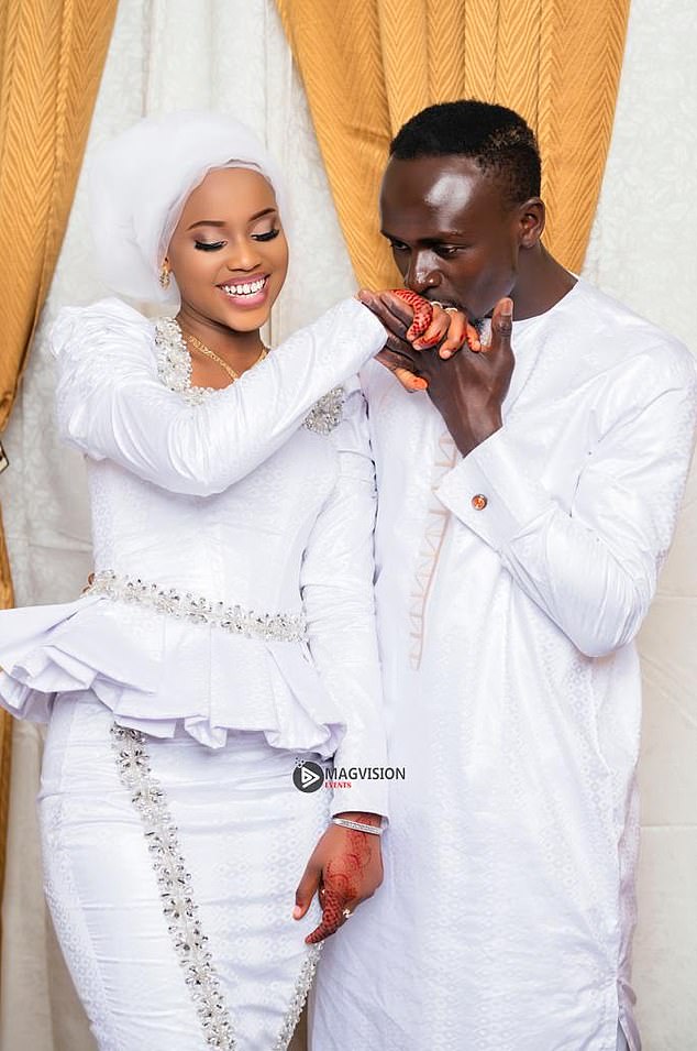 Sadio Mane kisses his new bride's hand during a wedding photo shoot