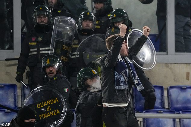 Police are forced to restrain a Lazio fan who tried to taunt full-time Roma fans