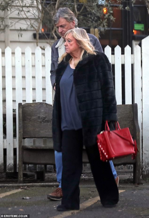 She added a pop of color to the daytime outfit by carrying her belongings in a red handbag