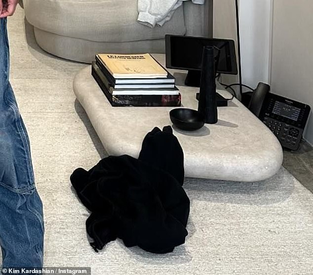 Kim had a coffee table without legs.  It can be seen on the right and it has books, a bowl and a learning gadget like a screen on it.  There is also a landline telephone on the floor