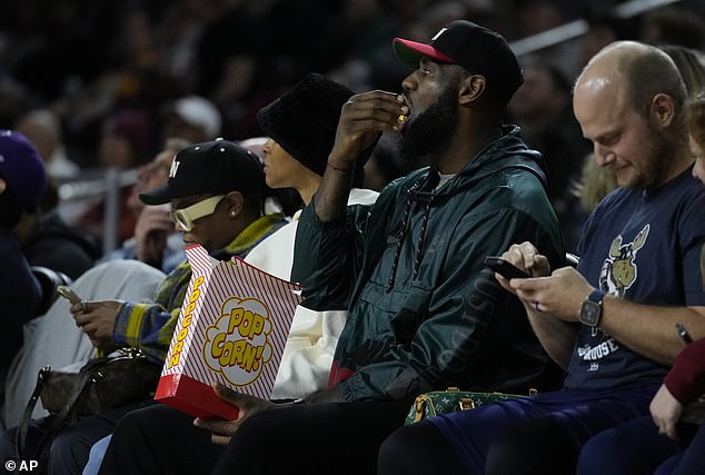 The 39-year-old Lakers star ate some popcorn in the first half while donning a cyan raincoat