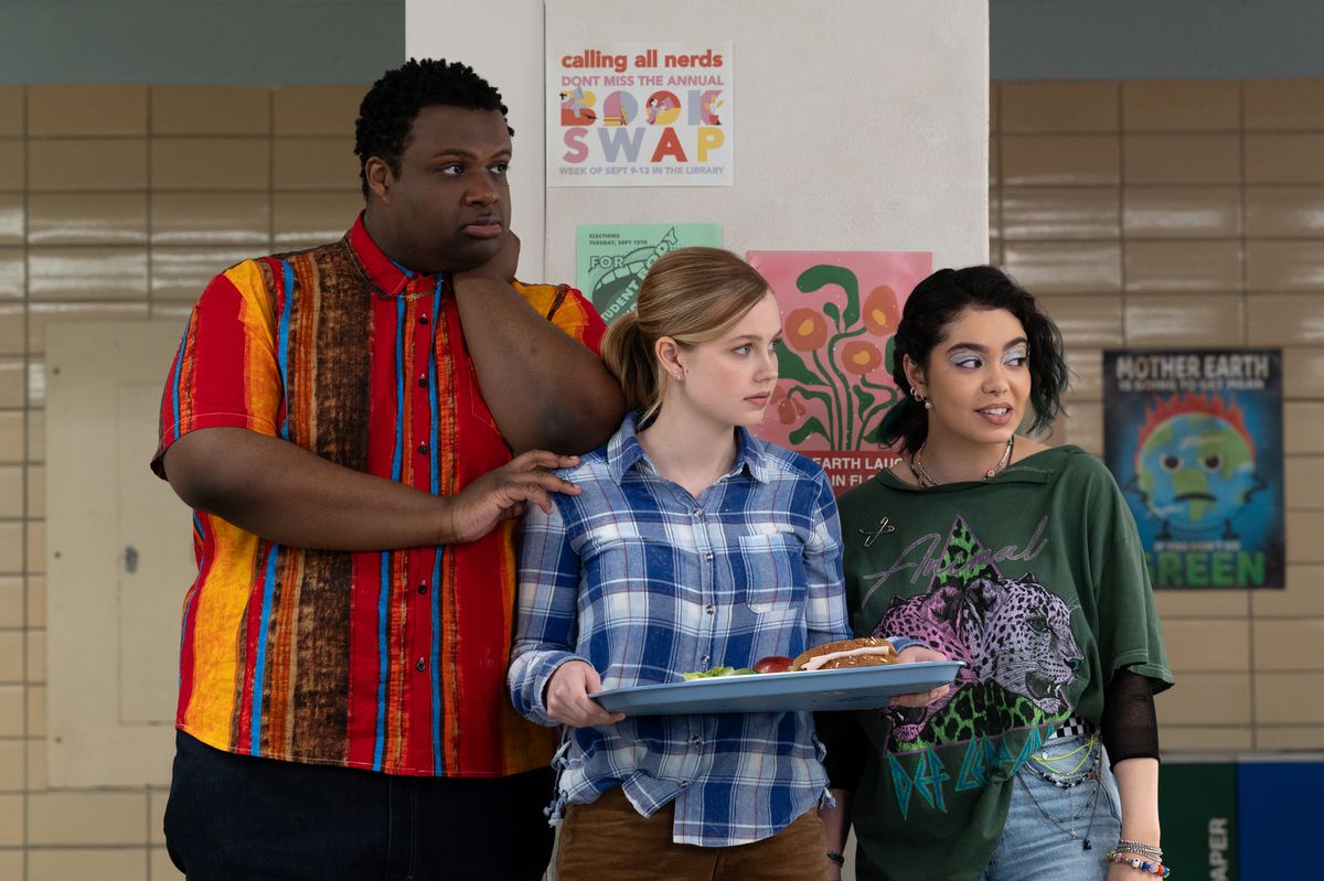 Damien, Cady and Janis stand at the edge of the cafeteria