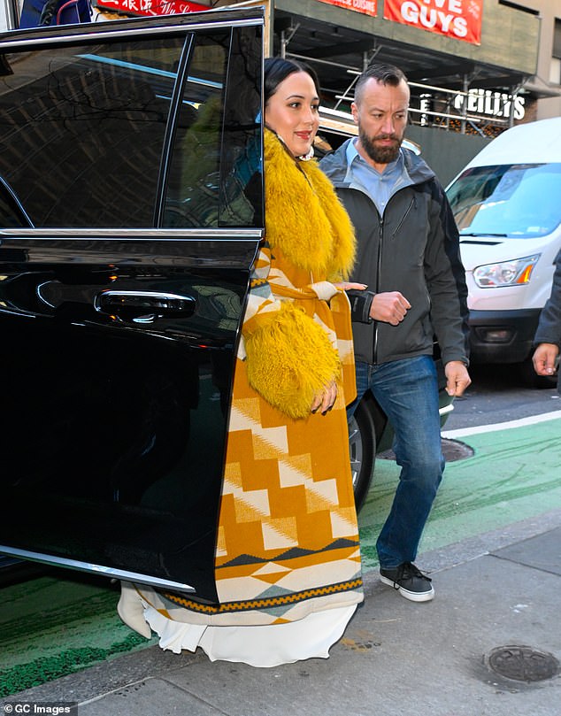 Her first outfit of the day consisted of yellow and white native-style designs with a thick furry collar and matching tufts of yellow down over the cuffs.