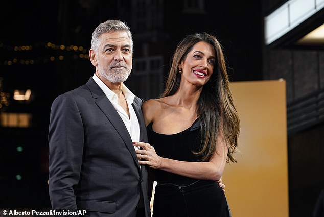 George Clooney and his wife Amal Clooney pose for photographers as they arrive at the screening of the film The Boys In The Boat on December 3, 2023 in London