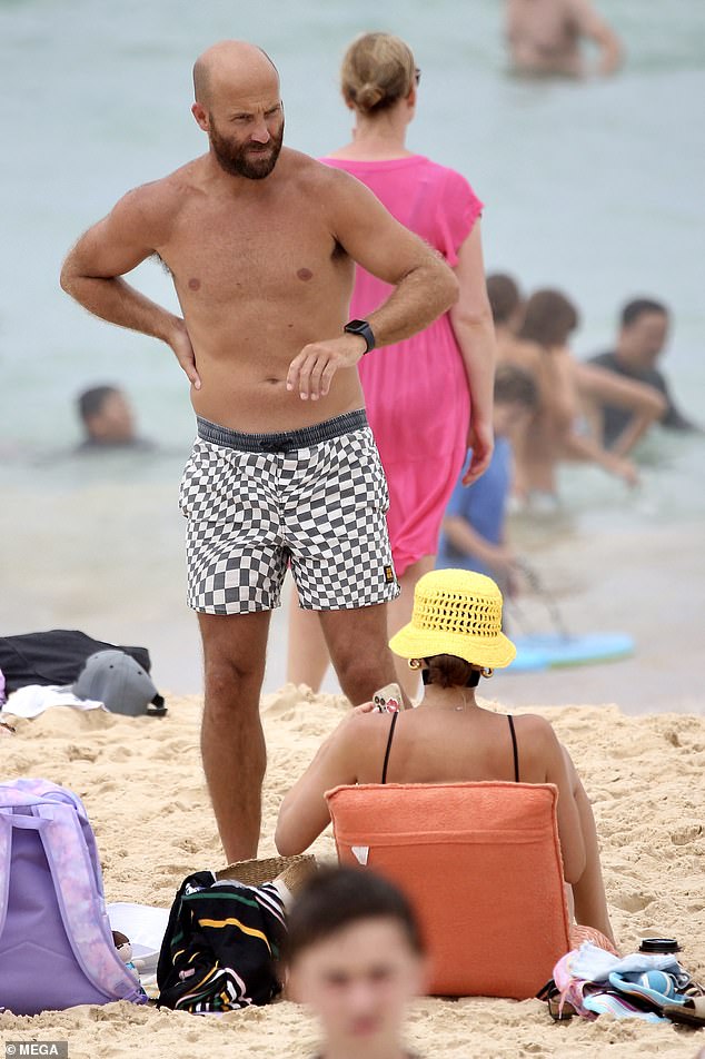 The former footy player wore gray and white checked board shorts