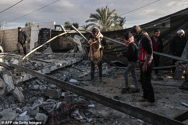 Palestinians check the damage to a house after the Israeli bombardment on January 12, 2024