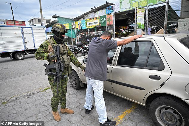 A member of the army's Elite Forces searches a man during a patrol in the streets of Carapungo, a popular neighborhood in northern Quito, on January 11, 2024