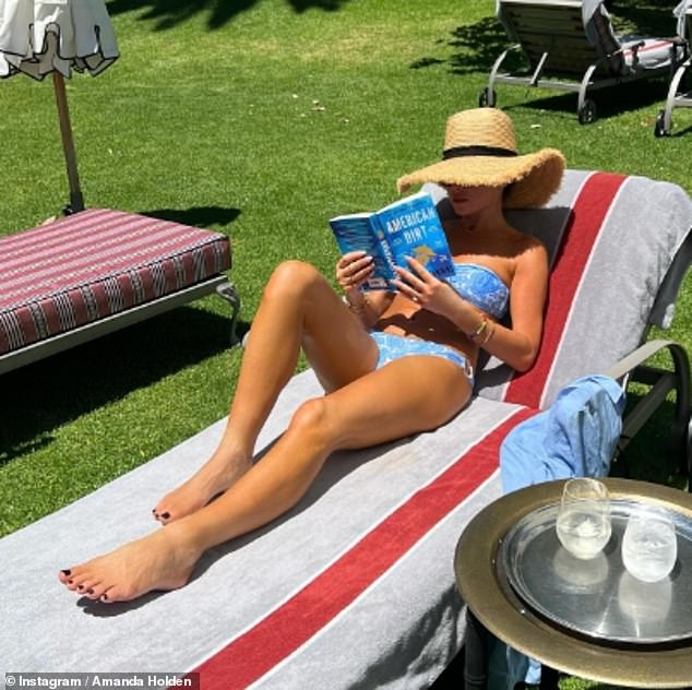 Via Instagram, the host gave fans a glimpse of her outing as she posed in a tiny two-piece while reading social issue thriller American Dirt at a resort.