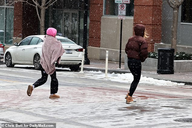 A girl in a blanket runs into the deserted streets of Kansas City on Friday evening