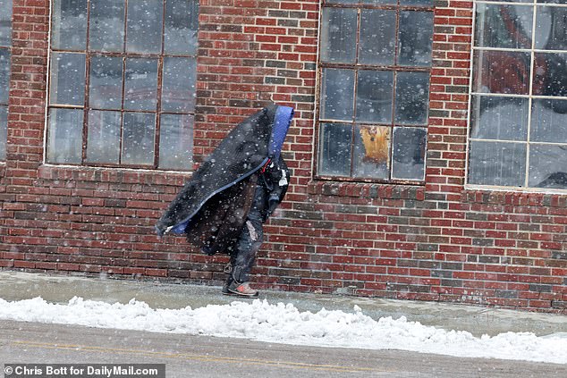 One man wraps himself in a blanket as the streets of Kansas City are virtually deserted on Friday