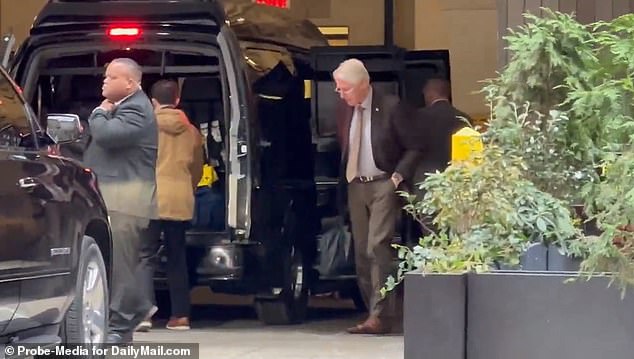 Clinton, wearing a brown suit, was seen exiting a vehicle while surrounded by Secret Service agents