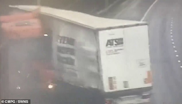 The front of the truck bends backward as it crashes into a fence along the highway