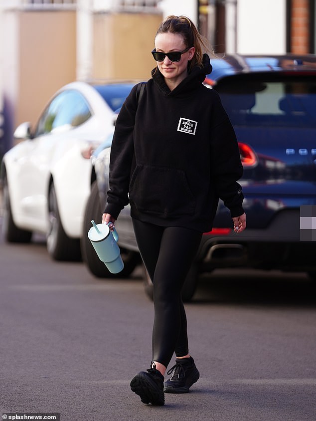 The star kept it casual in figure-hugging black leggings and a black hoodie with 'The Apple Pan' in white lettering on the left side - referencing the retro LA restaurant