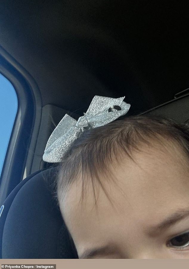 With a sweet silver bow on top of her head, Malti had taken a blurry selfie while strapped into a car seat