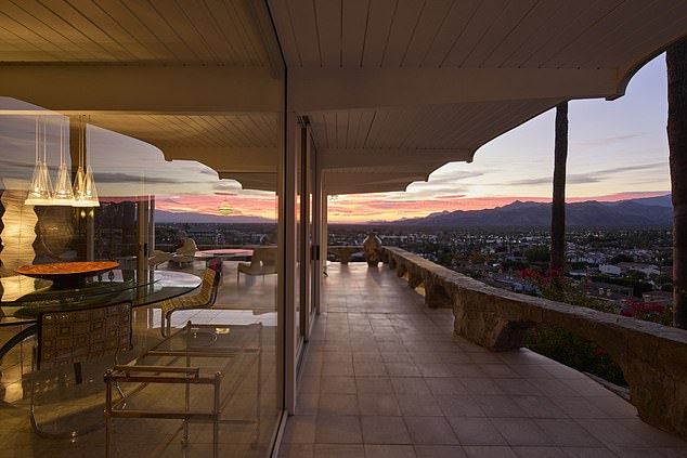 An expansive balcony with an arched roof supported by pillars extends the home's living areas outdoors, where you can enjoy breathtaking views of the Coachella Valley and surrounding mountains.