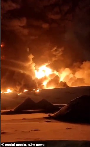 A video taken from a moving vehicle on the road shows huge flames spreading across the factory