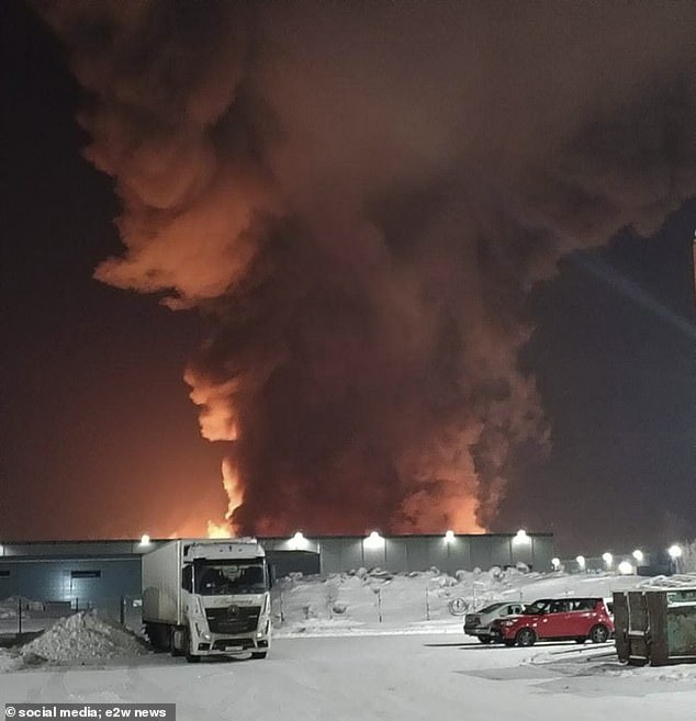 The fire rages in the factory for cars parked on a snow-covered lot in St. Petersburg