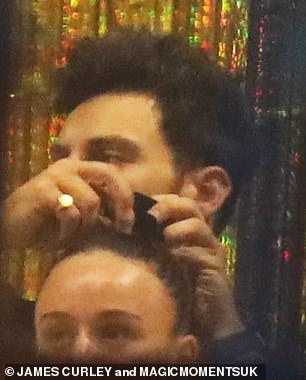 As they socialized, Vito tied the former Coronation Street star's hair up in a bun for her