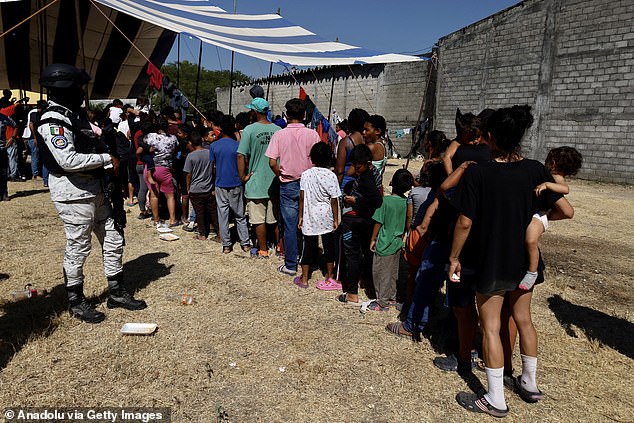 Mexican soldiers watch as migrants, walking with the migrant caravan heading to the U.S. border, wait in line to enter the shelter in Oaxaca, Mexico on January 9.