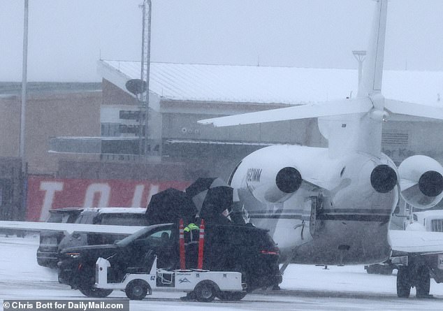 The 34-year-old billionaire shielded her face from the Arctic wind with an umbrella as she left the plane