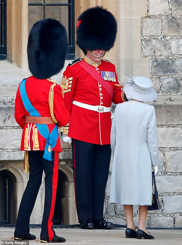 Queen Elizabeth II talks to Garrison Sergeant Major Andrew during a military parade