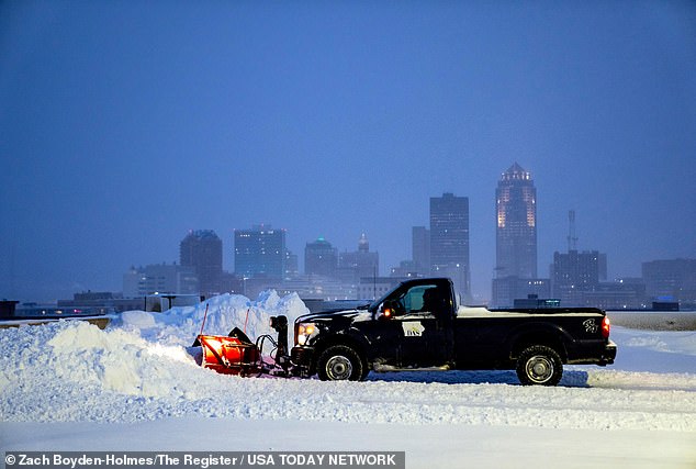 The Iowa Department of Administrative Services plows snow in the Capitol parking lot as snowstorms hit Des Moines on Friday