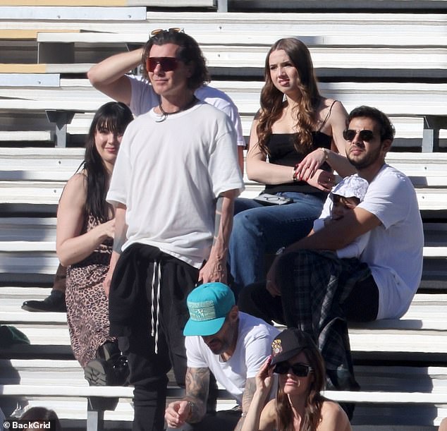 The model - who shares her little one with property developer Jordan Saul - attended the match with her musician dad Gavin Rossdale, 58 (center in white T-shirt)