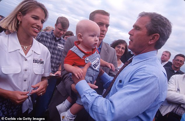 Texas Governor George W. Bush holds up a baby in Iowa in August 1999.  Bush went on to win the Iowa caucuses in 2000. He won the Republican nomination over chief rival Senator John McCain and then defeated Democratic Vice President Al Gore in the general election later that year.