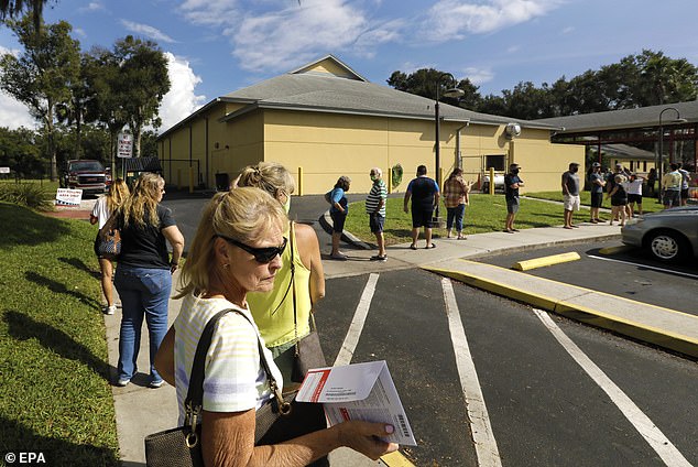 The decline in voters appears to be shifting from a routine registration list that moves people who have not voted in the past two elections to inactive status.  Pictured voters line up to cast their ballots in Palm Harbor, Florida on October 27, 2020