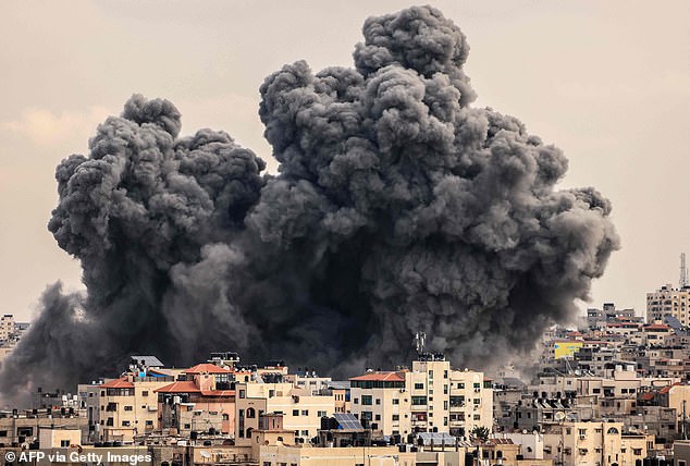 A plume of smoke rises into the skies of Gaza City during an Israeli airstrike on Monday