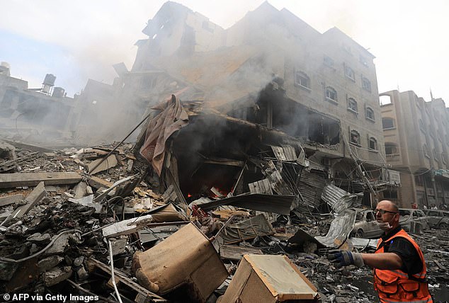 A Palestinian aid worker leads others after an Israeli airstrike on buildings in the Jabalia refugee camp in the Gaza Strip on Monday