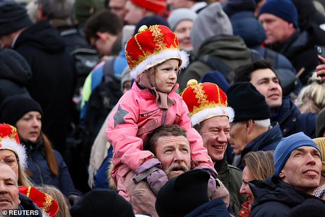 A child wearing a crown watches as people gather on the day Danish Queen Margrethe abdicates